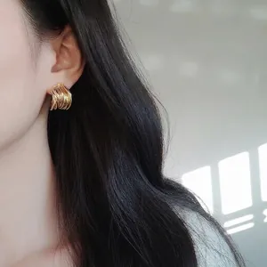 Minimalist gold-tone multi-layered twisted hoop earrings for a luxury aesthetic