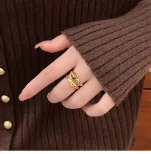 Detailed close-up showing a vintage gold-plated double-layer ring with tiger eye stone on a finger.