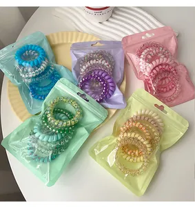 Macro view of colorful spiral hair ties sets in vibrant translucent packaging.