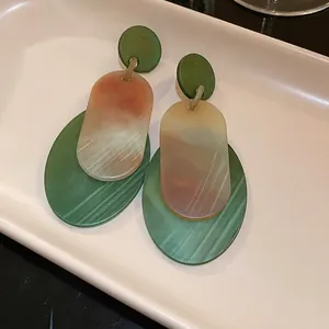 Retro style oval acrylic drop earrings featuring green and tan marbled layered design details