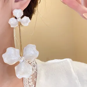 Detailansicht eleganter weißer Tropföl-Blumenohrringe mit feinen Perlenakzenten