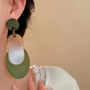 Vintage green acrylic oval layered drop earrings for women shown on an Asian model ear