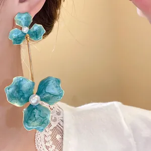 Detailaufnahme eleganter blaugrüner Emaille-Ohrhänger mit Perlen an einem Model