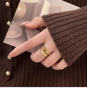 Close-up of a vintage gold-plated double-layer ring with tiger eye stone and zircon