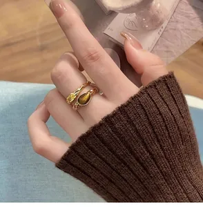 Close-up of vintage gold-plated double-layer ring featuring a tiger eye stone and zircon