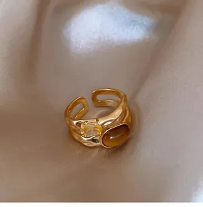 Macro view of a gold-plated double-layer ring with tiger eye and zircon stones.