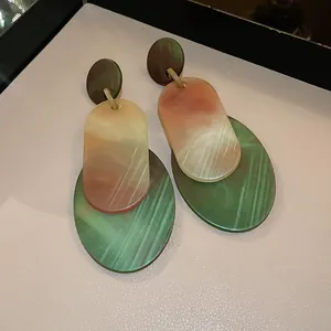 Detailed macro view of layered acrylic oval drop earrings with vintage marble texture