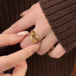 Detailed view of vintage gold-plated rings with tiger eye stone and yellow zircon