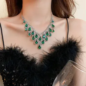 Primo piano di elegante collana a goccia verde smeraldo con strass scintillanti su modella