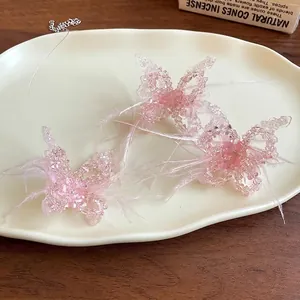 Süße elegante Halskette mit rosa Feder und Kristallschmetterling auf Keramiktablett