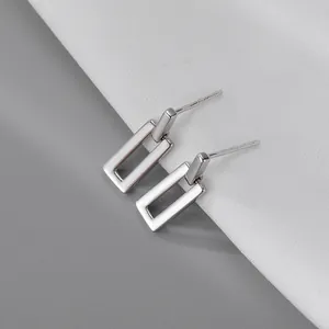 Close-up of sleek silver-tone rectangular drop earrings with S925 engraved posts