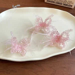 Detailansicht der rosa Perlen-Schmetterlingshalskette mit Federakzenten auf einem Keramiktablett