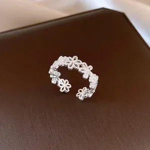 Nahaufnahme eines eleganten offenen Rings mit hohlem Blumenmuster in Silberoptik