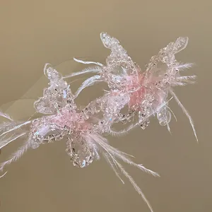 Detailansicht der zarten rosa Kristall-Schmetterlingskette mit eleganten weißen Federn.