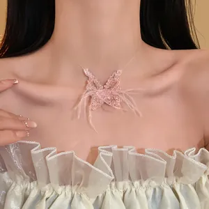Nahaufnahme einer süßen rosa Kristall-Schmetterlingskette mit Federn auf dem Model