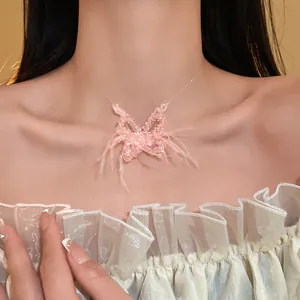 Nahaufnahme einer Halskette mit rosa Federn und Kristall-Schmetterling an einem Model
