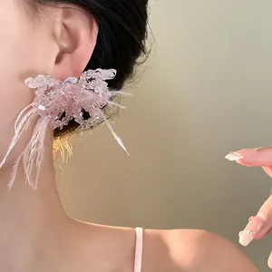 Detailaufnahme eines süßen rosa Kristall-Schmetterlings-Ohrrings mit Federakzenten