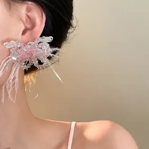 Detailansicht von Kristall-Schmetterlings-Ohrringen mit rosa Federn im Prinzessin-Stil