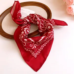Detail of a red sunflower paisley bandana tied in a stylish knot for hair accessories.