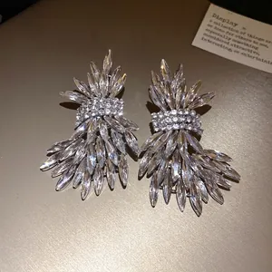 Elegant oversized crystal wing stud earrings with sparkling silver needle backings