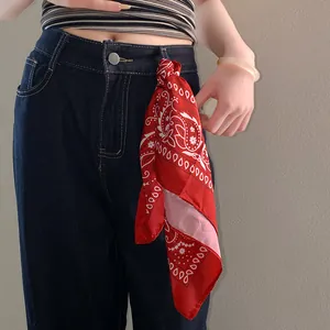 Red paisley print sunflower bandana scarf styled as a versatile accessory on jeans