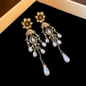 Exquisite detail view of vintage gold floral dangle earrings with white teardrop pearls