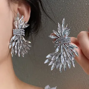 Detailed view of oversized marquise-cut crystal wing stud earrings with rhinestone accents