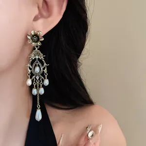 Detail shot of vintage gold chandelier earring with white faux pearl drops.