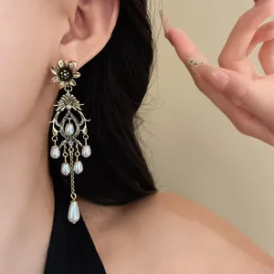 Close-up of vintage court-style earring with flower top and teardrop faux pearls.