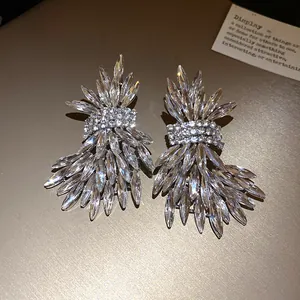 Detailed macro view of luxurious silver needle earrings with dazzling crystal wings