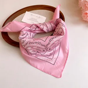 Detailed view of pink paisley print bandana hair accessory with silky satin finish