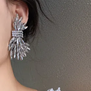 Close-up of luxury crystal wing stud earrings with silver needle and rhinestones