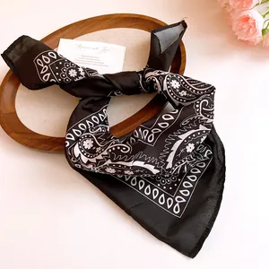 Detailed shot of a black sunflower paisley bandana tied in a knot on a decorative tray