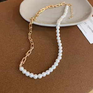 Close-up of French vintage necklace with half gold U-link chain and white pearls