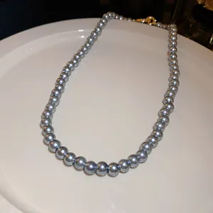 Detailed view of an elegant grey pearl beaded necklace with a vintage golden clasp