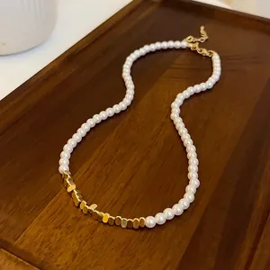 Detail view of French vintage necklace featuring white pearls and gold metal beads