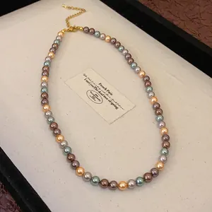 Exquisite detail of a French vintage multi-colored pearl necklace laid in a jewelry tray