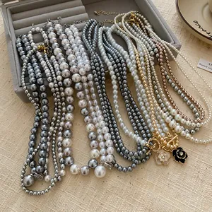 Detailed view of elegant vintage pearl necklaces featuring various sizes and flower pendants
