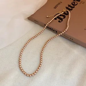 Detail of a champagne-colored pearl necklace with elegant golden gloss on a vintage book.