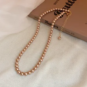 Detailed view of elegant champagne pearl necklace featuring gold adjustable chain