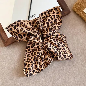 Dettaglio di un elastico per capelli vintage leopardato con texture in tessuto premium