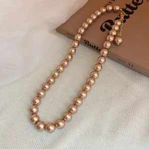 Close-up of champagne pearl necklace with French vintage style on textured background