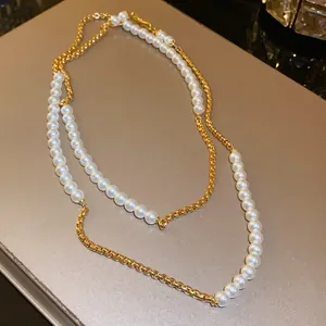 Close-up view of French retro necklace featuring elegant white pearls and a golden chain.