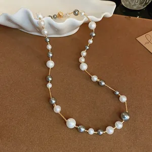 Elegant grey and white pearl beaded necklace with gold-tone accents in a macro view