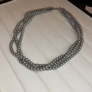 Macro view of an elegant three-strand grey pearl necklace with a lustrous finish