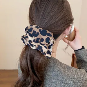 Vista dettagliata di un elastico per capelli vintage con stampa leopardata su una coda di cavallo