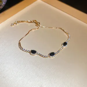 Pulsera ajustable dorada estilo coreano con piedras negras y detalles de cristales pavé