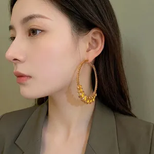 Elegant oversized gold hoop earrings with yellow teardrop crystal embellishments