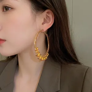 Statement oversized hoop earrings with amber crystals in a vintage gold finish.