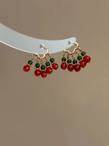 Detailed view of Chinese style hoop earrings with elegant red and green bead clusters